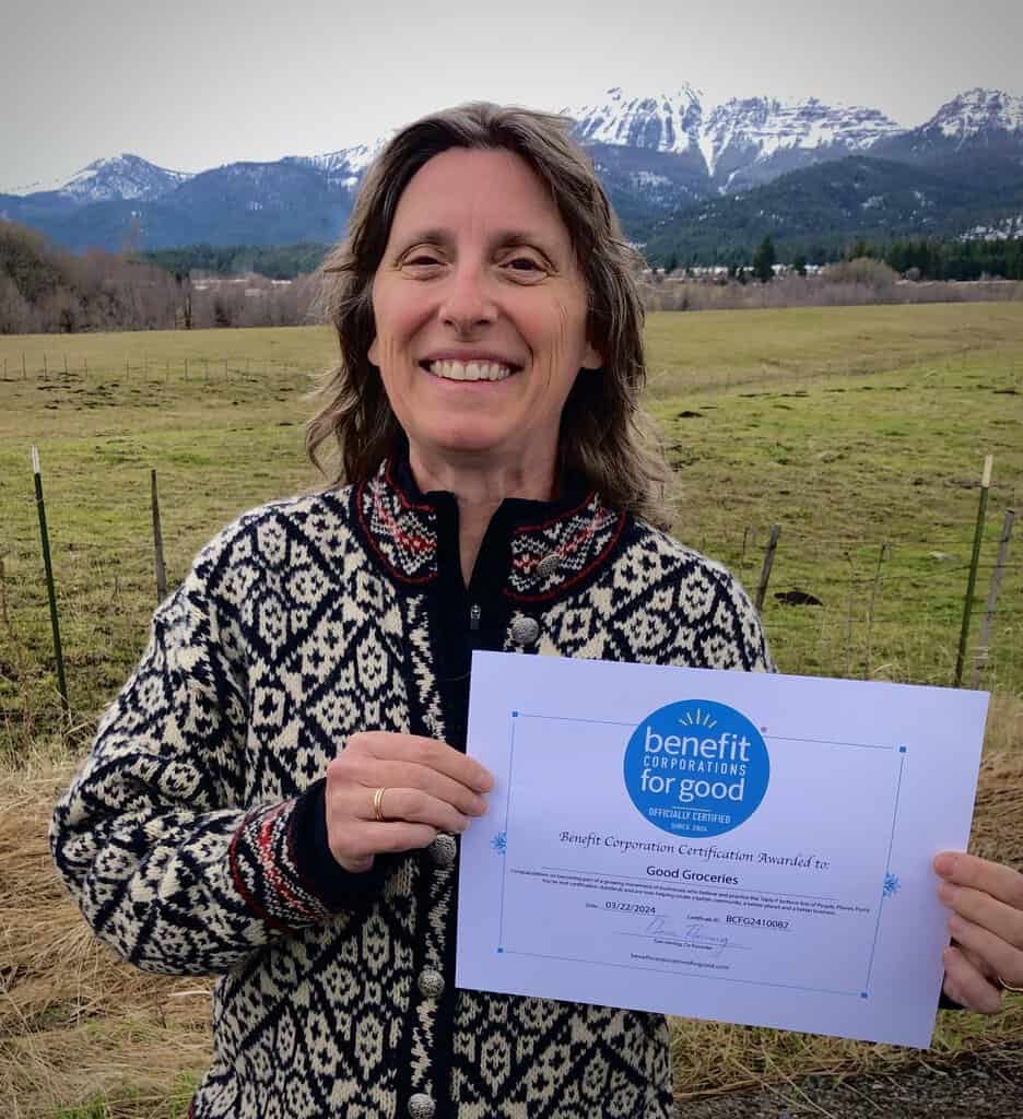Kristy Athens smiling and holding the Benefit Corporation for Good certificate.